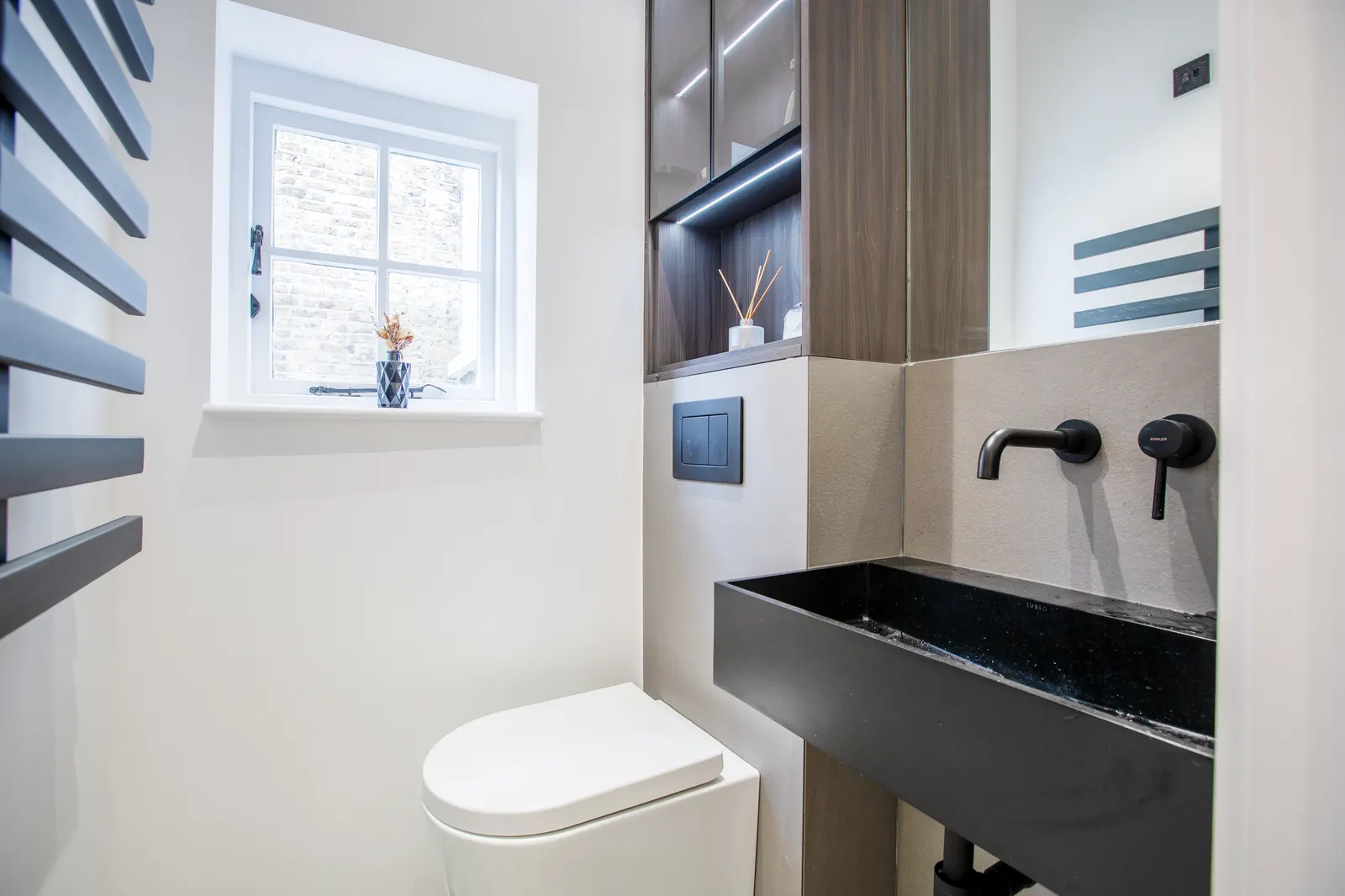 Cloakroom with black basin and matt black tap