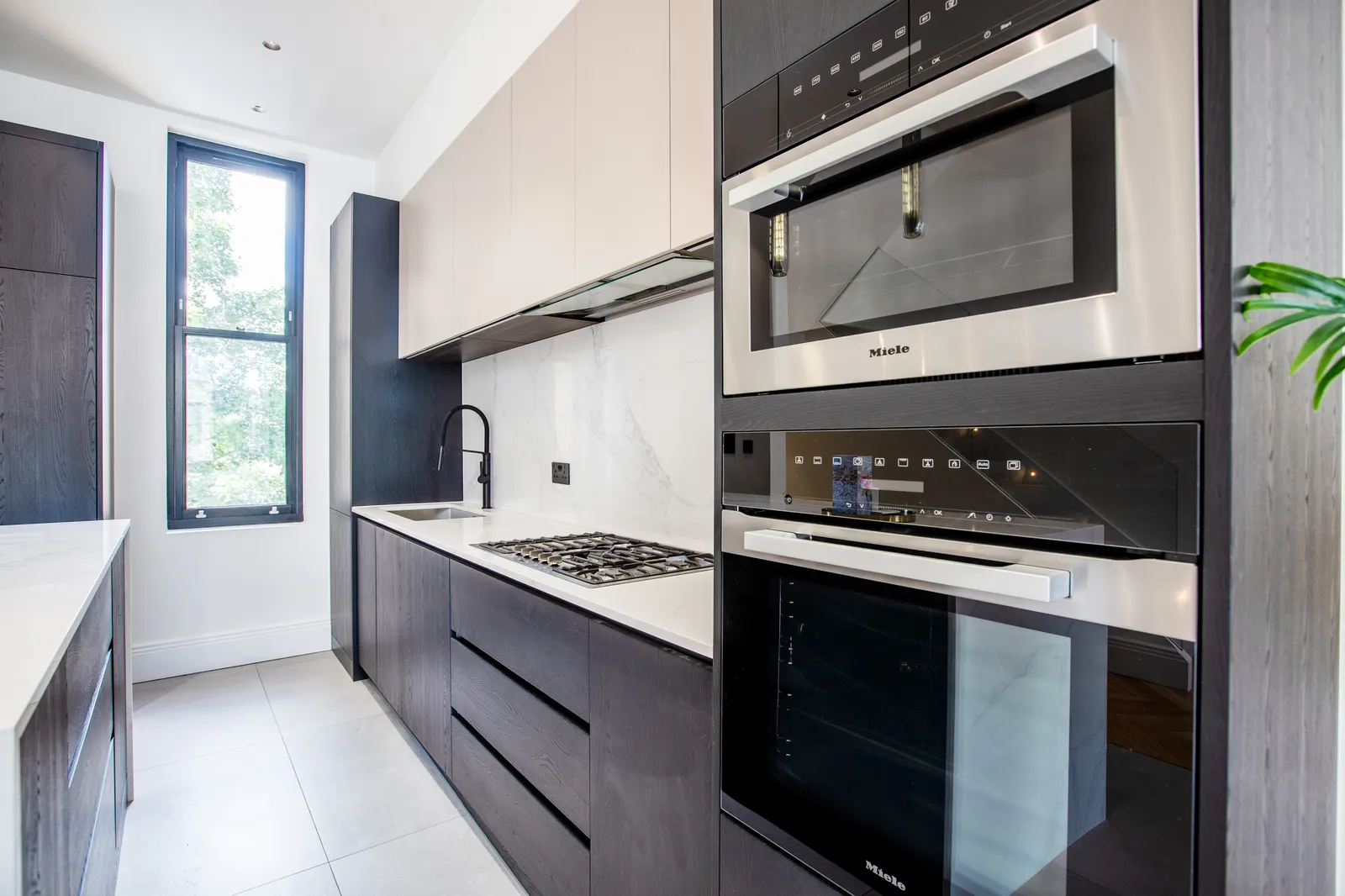 Kitchen with integrated ovens and black units