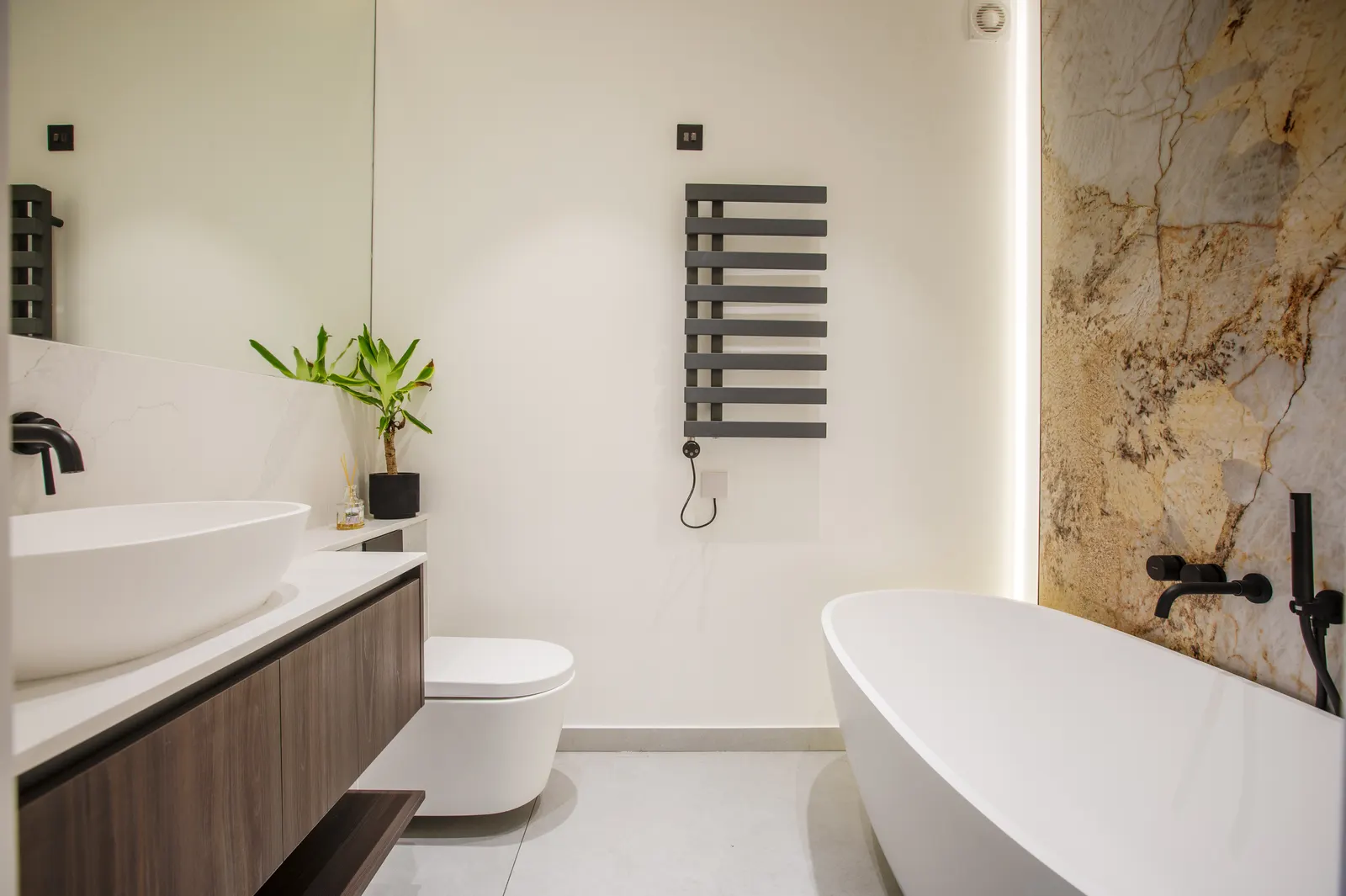 Bathroom with bath against marble wall