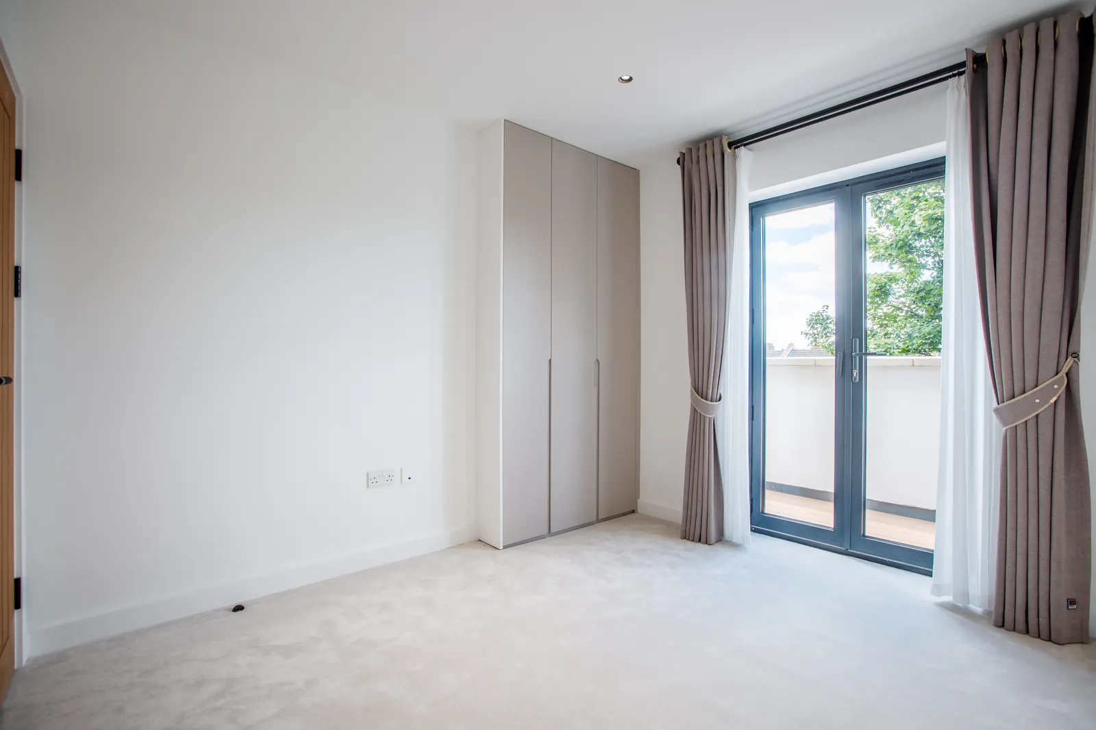 Bedroom with wardrobes by the window