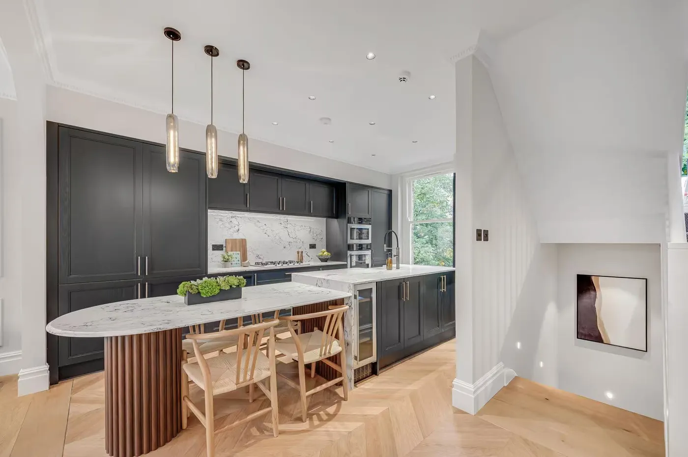 Kitchen with dark island and pendant lighting